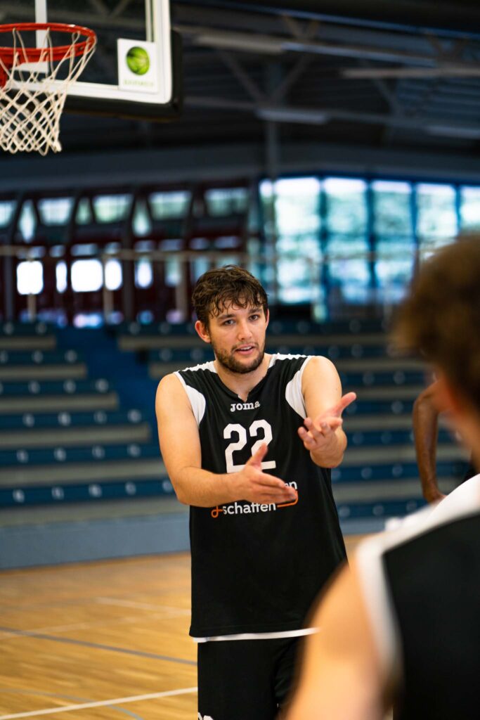 Baskeballer Cosmo Grühn gestikuliert während Spiel in einer Halle