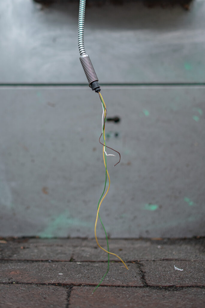 Hörerkabel, aus dem drei dünnere Kabel abgeschnitten heraushängen