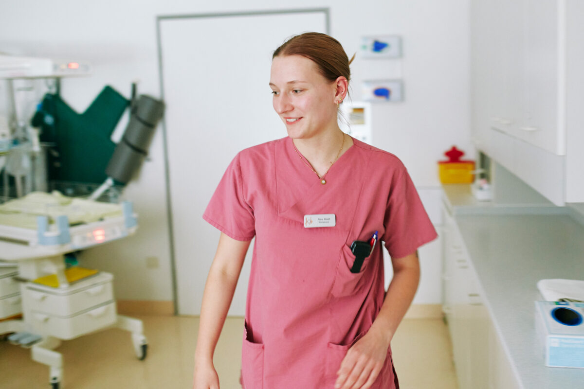Eine Hebamme läuft durchs Behandlungszimmer