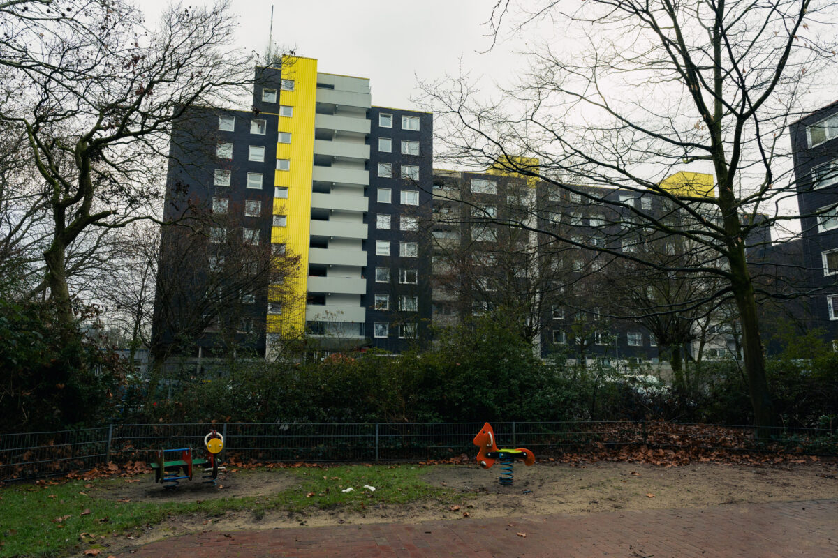 Vor dem Hochhaus ist ein kleiner Spielplatz