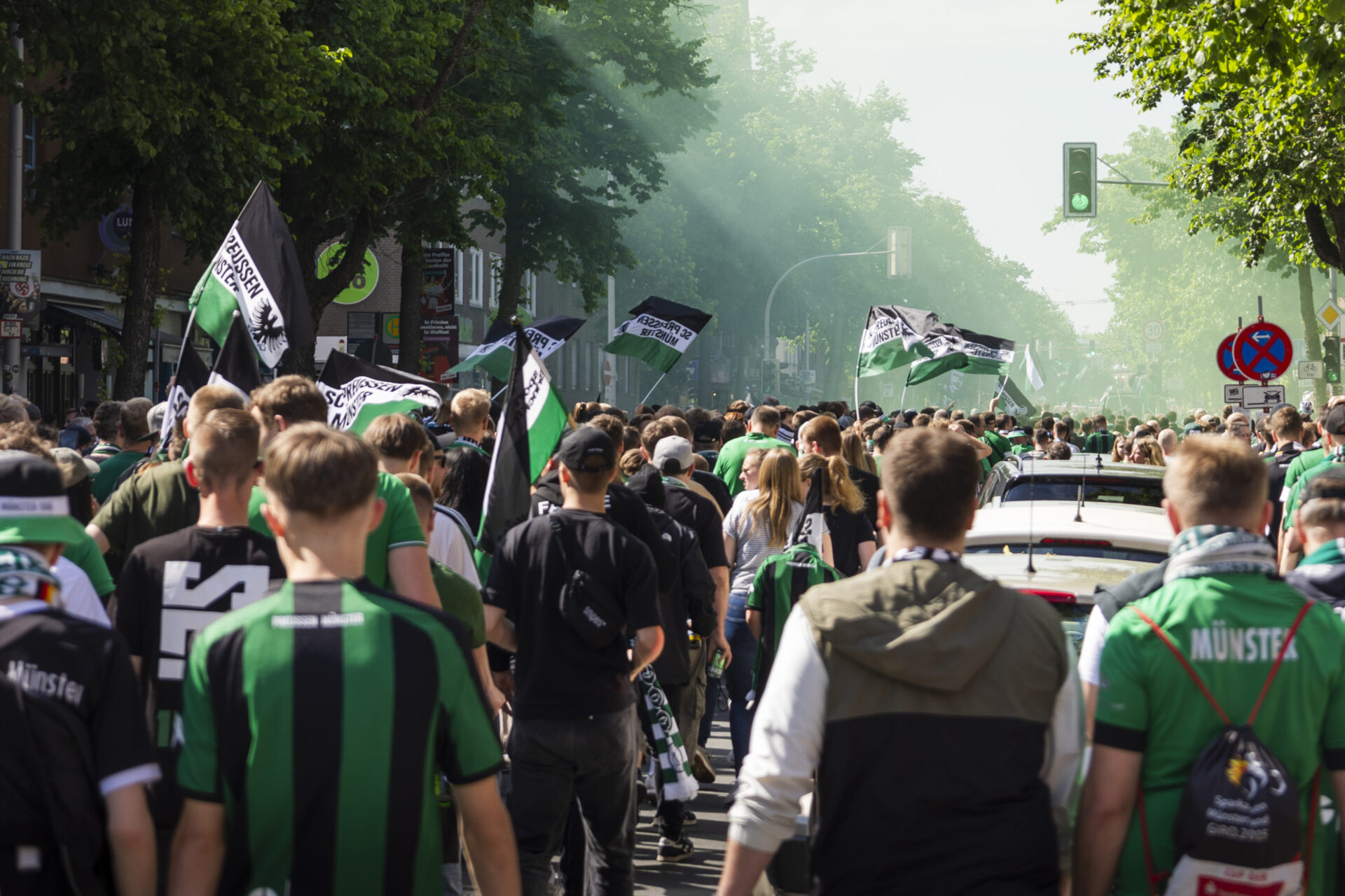Foto, auf dem Preußen-Münster-Fans gemeinsam durch die Stadt zum Stadion ziehen.