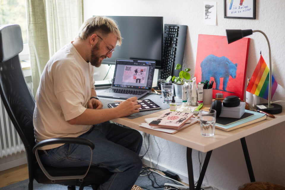 Julius Thesing arbeitet an seinem Schreibtisch in seiner Wohnung.