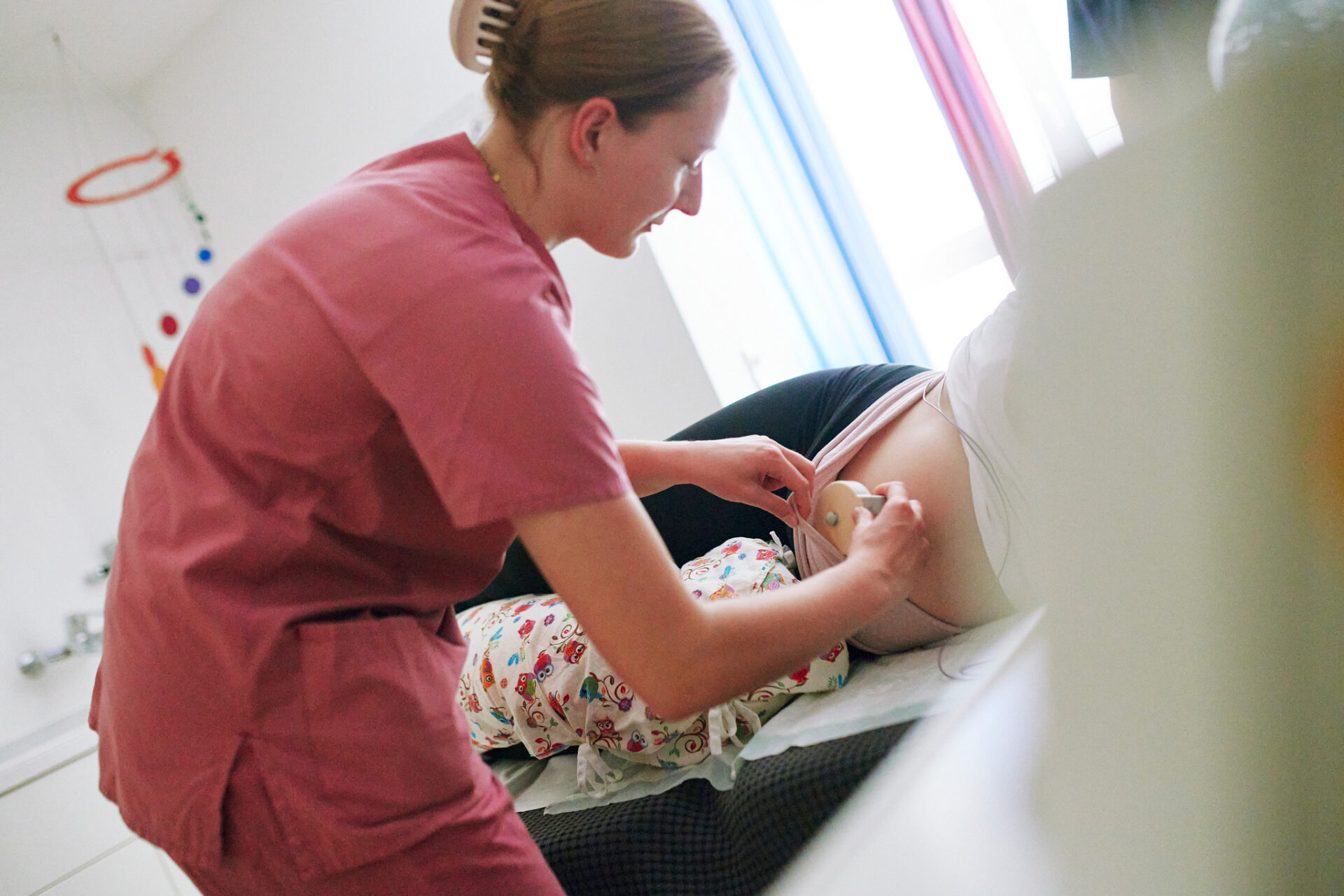 Eine Hebamme unterstützt eine Schwangere im Kreißsaal